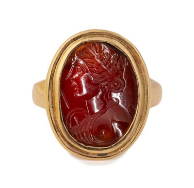 gros plan d'une bague en or avec une pierre rouge au centre