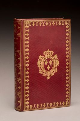 a red and gold book with a gold emblem on it