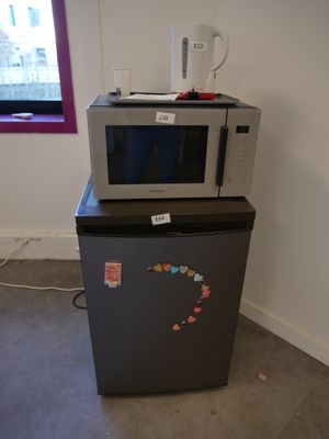 a microwave sitting on top of a refrigerator in a room