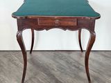 une petite table en bois avec un plateau vert, posée sur un parquet en bois dur