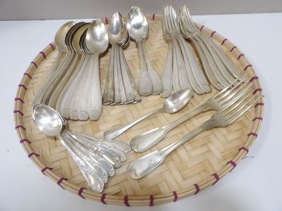 de nombreuses cuillères en argent et des cuillères à soupe disposées sur un plateau en osier