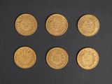six different types of gold coins on a black surface