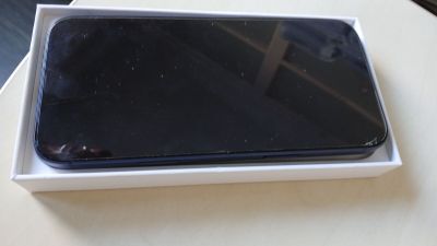 un téléphone noir dans une boîte blanche posée sur une table