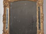 an image of a gold framed mirror sitting on top of a white wall
