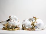 two white and gold figurines sitting next to each other