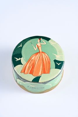 a small tin box with a woman in a dress on it
