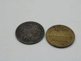two coins sitting next to each other on a white surface