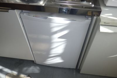 un lave-vaisselle blanc installé dans une cuisine, à côté d'un évier