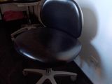 une photo d'une chaise de bureau noire dans un coin d'une pièce