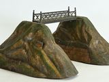 deux statues représentant un pont au sommet d'une montagne