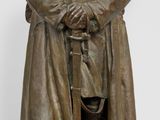 statue en bronze représentant un homme vêtu d'un trench-coat et d'un chapeau