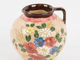 a vase with flowers painted on it on a white surface