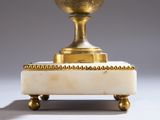 brass and marble urn on stand on grey background