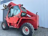 a red tractor that is parked in front of a building
