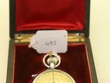 une petite montre de poche en argent dans un étui rouge