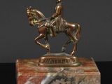 bronze statue of a man on a horse on a marble base