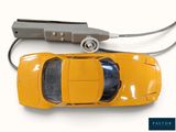 a yellow toy car that is connected to a charger