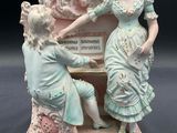 a figurine of a woman and a child playing a piano