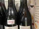 plusieurs bouteilles de vin sont alignées sur une étagère dans un magasin