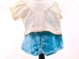un pull blanc et une jupe bleue sur un mannequin