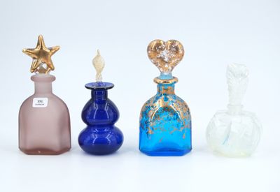 four different colored glass bottles are lined up on a white surface