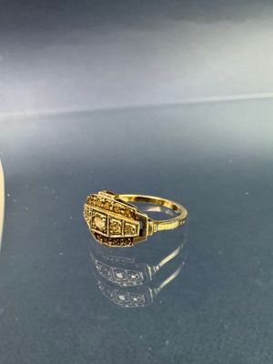 une photo d'une bague en or posée sur une table