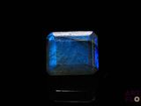 a close up of a blue stone on a black surface