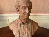 statue of a bust of a man on a table with a chain around his neck