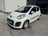 la petite voiture blanche est garée devant un bâtiment