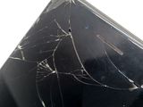 someone is holding a broken cell phone with a cracked screen