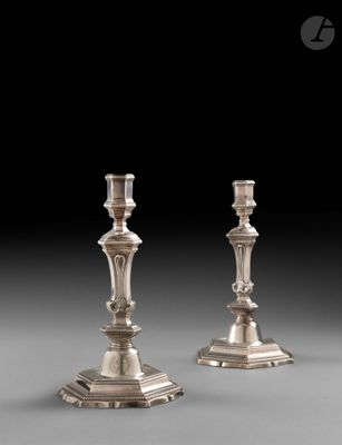 une paire de bougeoirs en argent sur fond gris