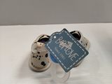 a small cup with a tag on it next to a pair of shoes
