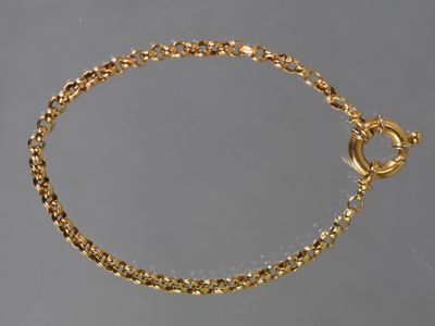 un gros plan sur un bracelet en chaîne dorée muni d'un fermoir