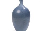 a blue vase that is sitting on a white surface