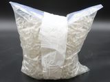 a bag of shredded white paper on a black surface