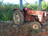 a red tractor that is parked in the dirt