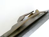 une sculpture métallique représentant un couteau et une fourchette posés sur un morceau de métal