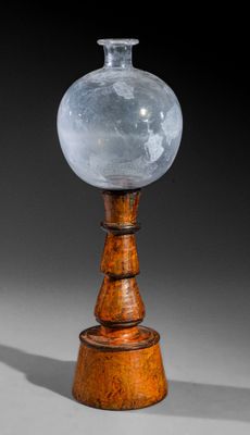 une image représentant un vase en verre posé sur un socle en bois