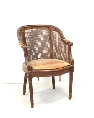 une image représentant une chaise avec un dossier en rotin et un coussin posé dessus