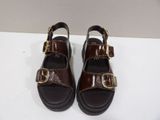 brown leather sandals with gold buckles and buckles on the toes
