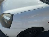 une petite voiture blanche garée sur le parking