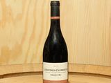 une bouteille de vin posée sur un tonneau en bois