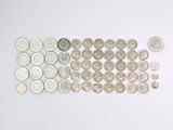 Plusieurs types de pièces de monnaie sont disposés en rangée sur une surface blanche