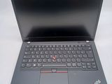 the laptop is open on a white surface with a red button on the keyboard
