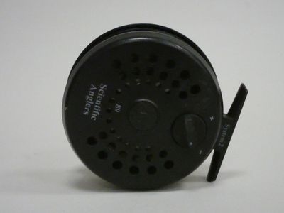 a close up of a fishing reel on a white surface