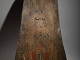 an old wooden object on a white surface with a shadow