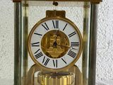 une horloge dorée ornée de chiffres romains, posée sur une table
