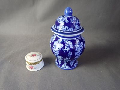 a small blue and white jar next to a smaller blue and white jar