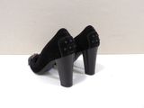 pair of black high heeled shoes sitting on a white surface