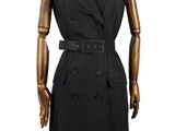 Le mannequin porte un manteau noir et une robe noire.